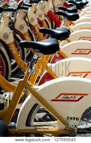 Milan, Italy - September 5th 2015: closeup photo of yellow and white hire bicycles in Milan Italy.