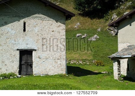 photo of a sunlit traditional house at Piani d'Erna (part of the Alps) near Lake Como in Italy