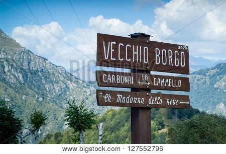 Piani d'Erna Italy - September 7th 2015: a wooden sign photographed at Piani d'Erna part of the Italian Alps near Lake Como Italy (Vecchio Borgo is a hotel Carbonai and Cammello are local walks Ch. Madonna della neve is a church)