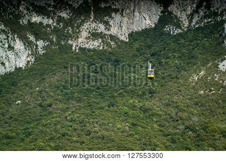 a yellow cable car carrying passengers down from Piani d'Erna (part of the Italian Alps)