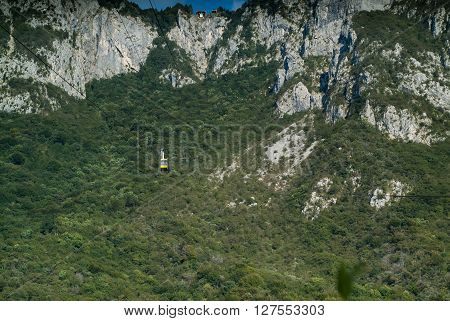 a yellow cable car carrying passengers down from Piani d'Erna (part of the Italian Alps)