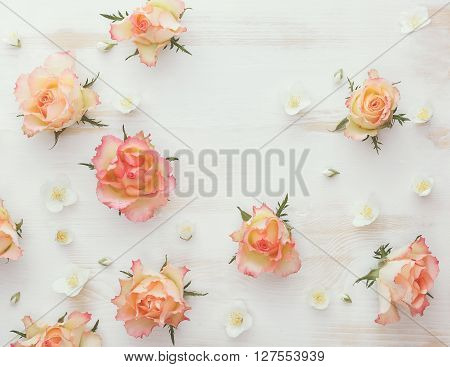 Roses and jasmine natural flower background. Various soft roses and and jasmine flowers scattered on a vintage background, overhead view, vintage toned image