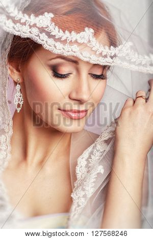 Portrait of a beautiful woman in a wedding dress in the image of the bride. Wedding. Young Gentle Quiet Bride in Classic White Veil. Portrait of beautiful bride. Wedding dress. Wedding decoration