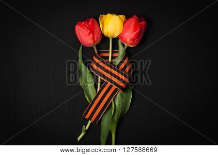George ribbon red and yellow tulips on a black background