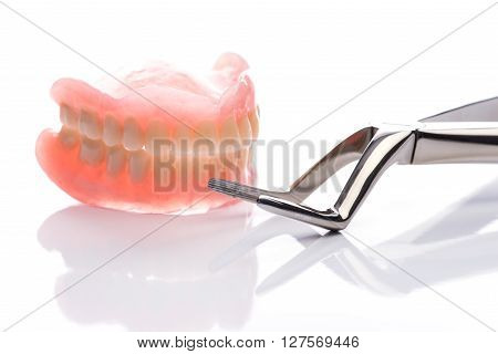 Teeth Model With Forceps On White Background