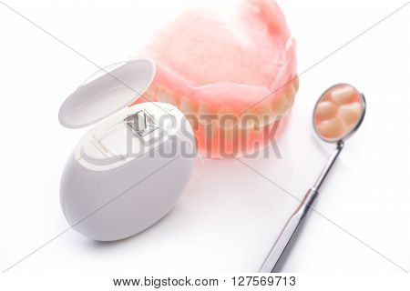 Teeth Model With Dental Floss And Mouth Mirror On White Background