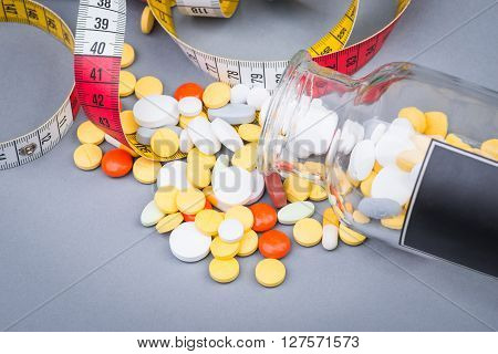 A Bottle Of Diet Pills With Measuring Tape