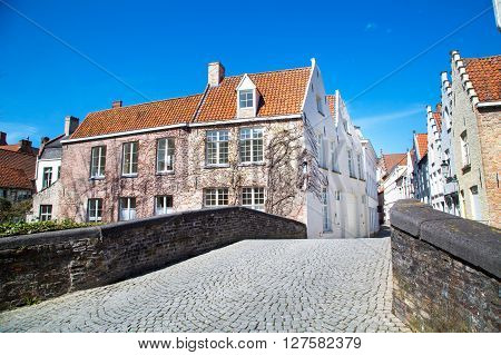 View across the bridge at colorful traditional houses against blue sky in popular belgian destination Brugge, Belguim