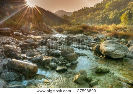 Beautiful Reshi River water flowing on rocks at dawn Sikkim India - sun rays at the background falling on water making spectacular view tinted image
** Note: Soft Focus at 100%, best at smaller sizes