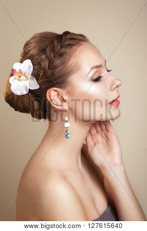 portrait of the beautiful young girl in an image of the bride with ornament in hair.Beautiful Professional Holiday Make-up.Glamorous Woman