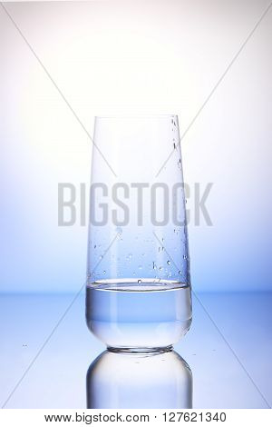 One-third Full Drinking Glass With Reflection In Drops Of Water