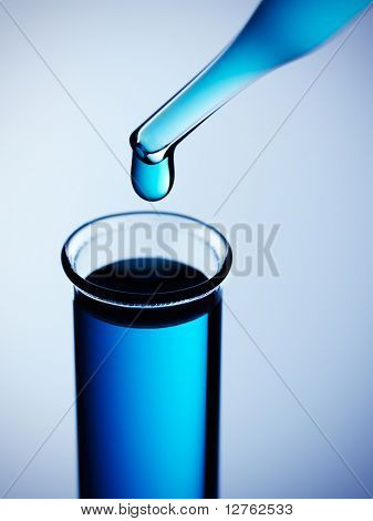 Provetta con pipetta su sfondo blu