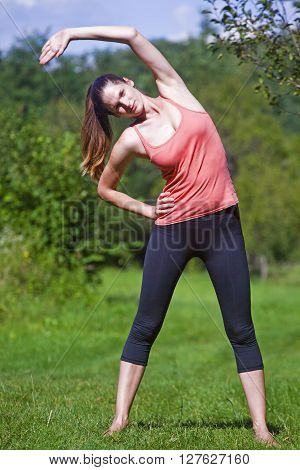 Young women practise sport by day in nature