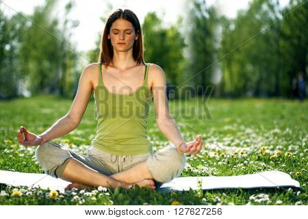 Young women practise yoga by day in nature