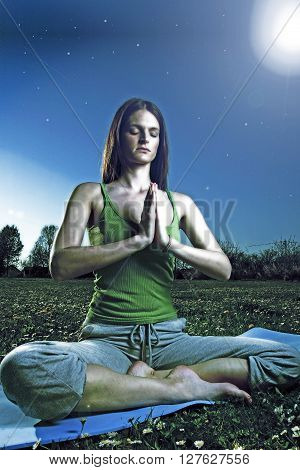 Young women practise yoga by day in nature