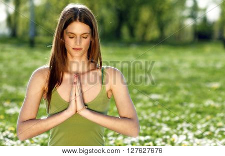 Young women practise yoga by day in nature
