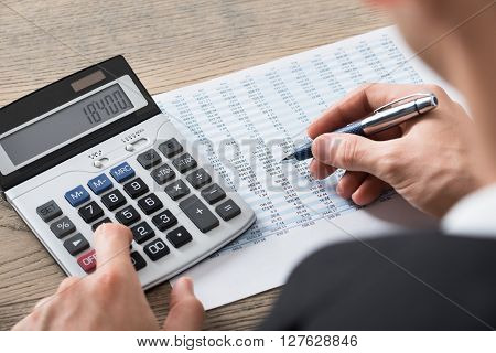 Businessman Analyzing Accounting Document With Calculator