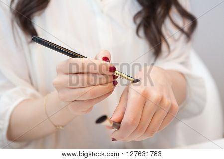 Makeup artist trying new makeup brushes on her hand