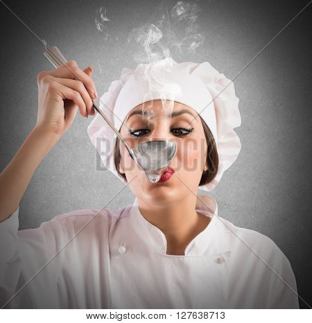 Woman taster chef tastes a steaming ladle