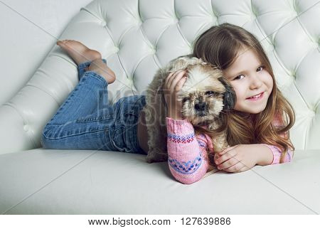 happy girl with her dog on the sofa at home