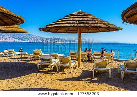 EILAT ISRAEL - FEBRUARY 23 2016: The beache of Eilat are very comfortable they are equipped by big beach umbrellas and soft beach chaise lounge on February 23 in Eilat.