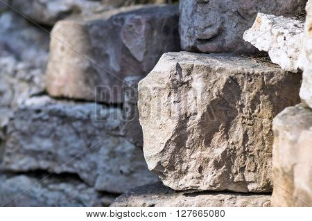 big piece of a stone closeup on an indistinct background from other stones