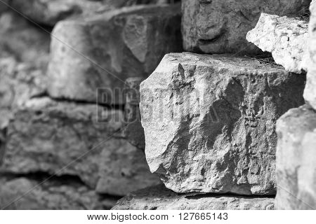 big piece of a stone closeup on an indistinct background from other stones of monochrome tone