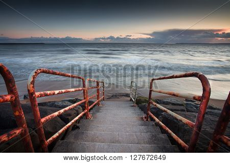 Rusty handrail leading to the beach at Aberavon, Port Talbot, UK.