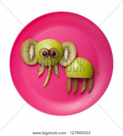 Elephant made of apples kiwi and grape on plate