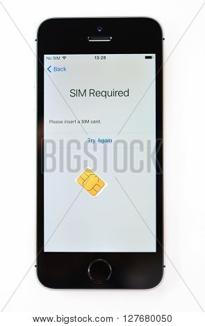 PARIS FRANCE - APR 21 2016: First start of the new iPhone SE with SIm required message on screen - the new phone combines the updated processor 4K rear camera touch id retina display