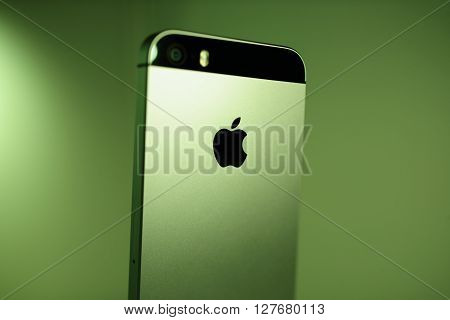 PARIS FRANCE - APR 21 2016: Rear view of the new Apple iPhone SE on green background with Apple logo and detail of the new Camera - it features updated processor 4K rear camera touch id retina display