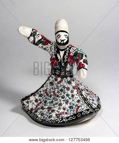 Souvenir statuette of ceramics. Statuette depicts a dancing dervish in torque. In the suit floral ornament.