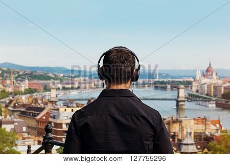 Young man listening music back view Budapest Hungary