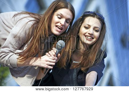 Young women singing outside and having fun