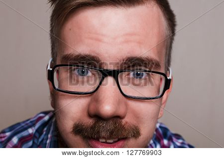 Close up portrait of hipster. kind person wath into camera. Big face with glasses and beard