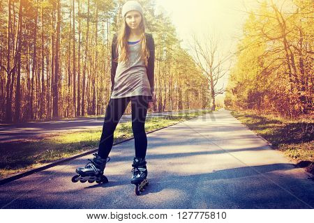 Teenage girl on roller skates at summer. Inline skates sport conceptual image. Instagram vintage picture.