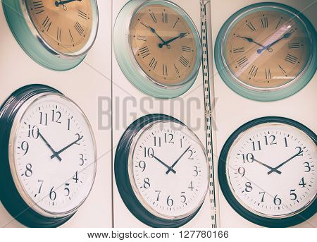 Clocks hanging on wall. Abstract background with vintage filtered.
