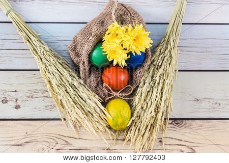 Easter morning: eggs  and yellow flowers on wood background