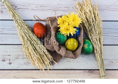 Easter morning: eggs  and yellow flowers on wood background