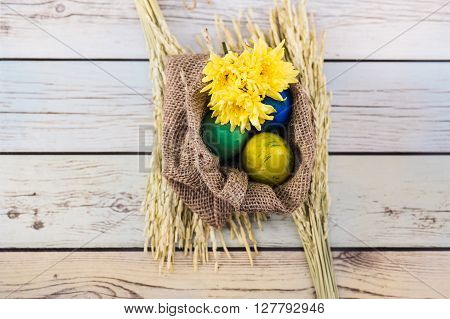 Easter morning: eggs  and yellow flowers on wood background