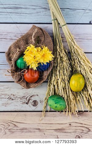 Easter morning: eggs  and yellow flowers on wood background