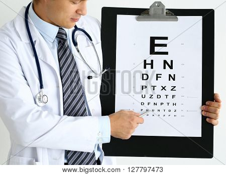 Medicine doctor hold big clipboard pad with eyesight check table and point with silver ballpoint pen to it. Excellent vision laser surgery alternative driver certificate examination concept