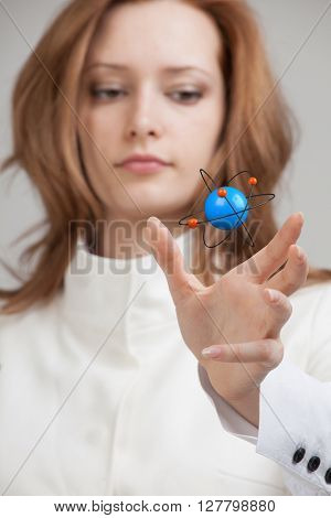 Woman scientist with atom model, research concept
