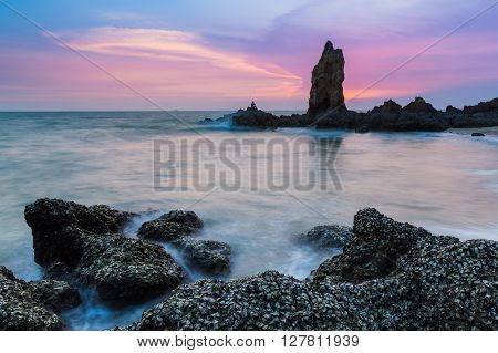 Rocky seacoast long exposure with dramatic sky after sunset