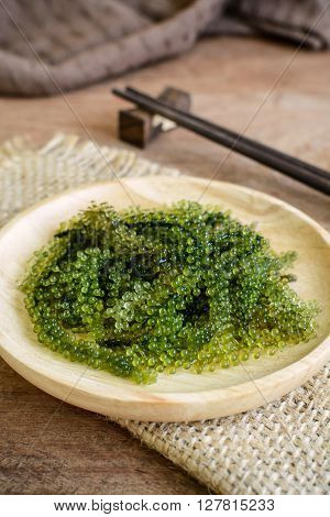 Sea Grapes (Caulerpa Lentillifera) seaweed on wooden table