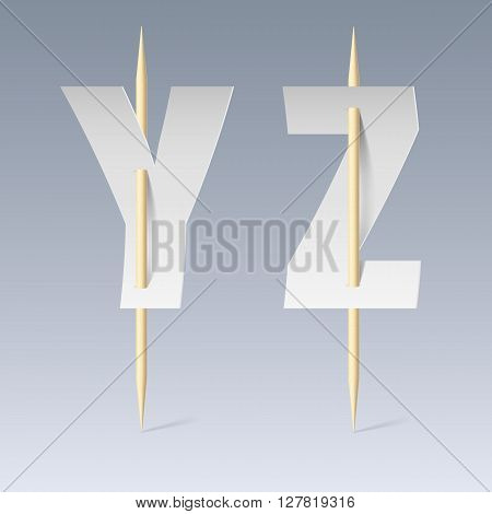 White paper cut font on toothpicks on grey background. Y and Z letters