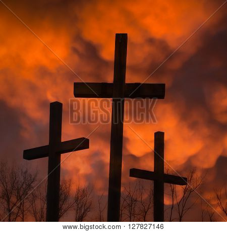 three crucifixes and mammatus clouds on dark night