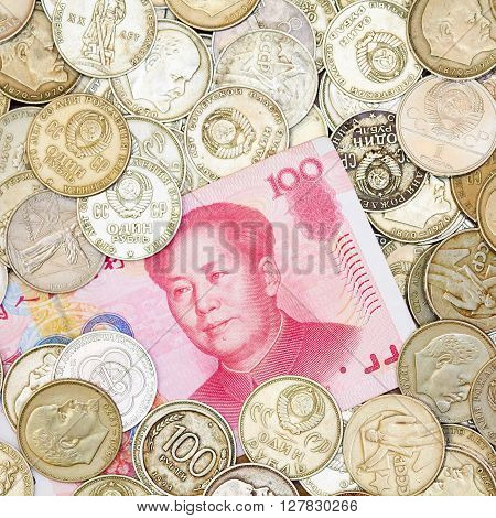 Photo of one hundred yuans lying on heap of old coins. Currency exchange illustration