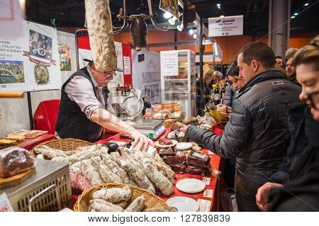 People Buying Meat From Butcher At Covered Market
