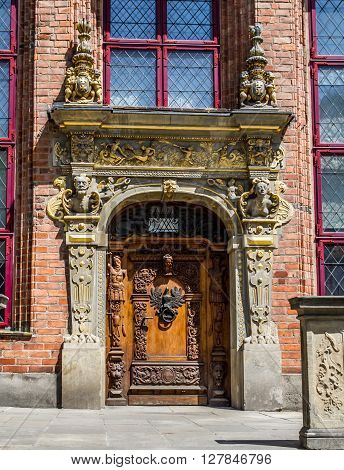 Old vintage wooden door decorated with sculptures and with door knocker in the form of a eagle